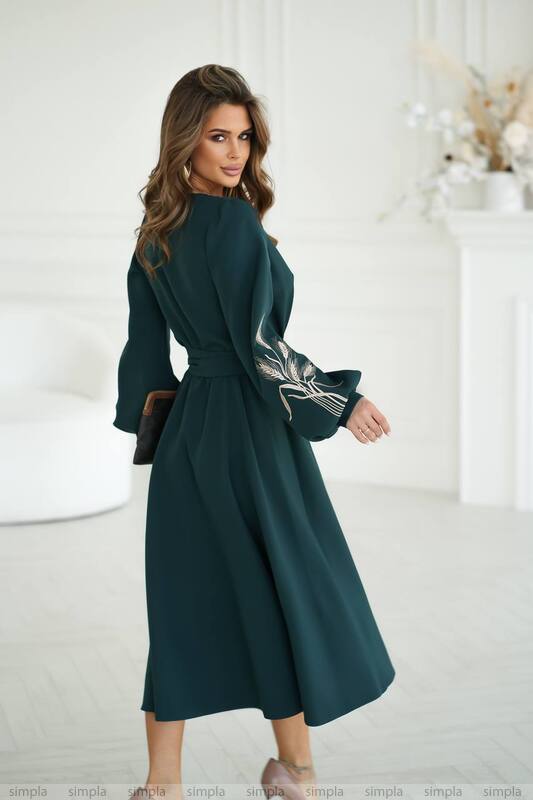 Woman wearing a dark green dress with a white background