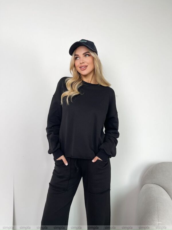 Woman wearing a black outfit with a cap against a white background