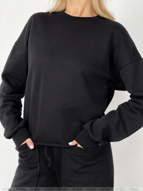 Person wearing a black sweatshirt and pants on a white background