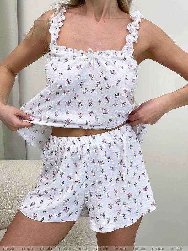 White floral pajama set worn by a person on a plain background