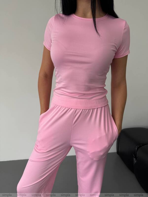 Person wearing a pink outfit with a plain background