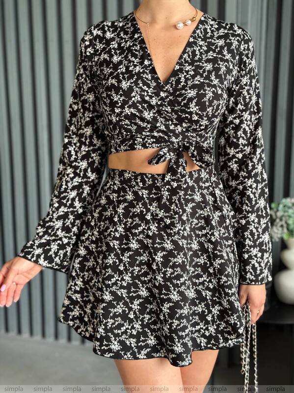 Black and white floral dress with long sleeves and a belt, worn by a person.