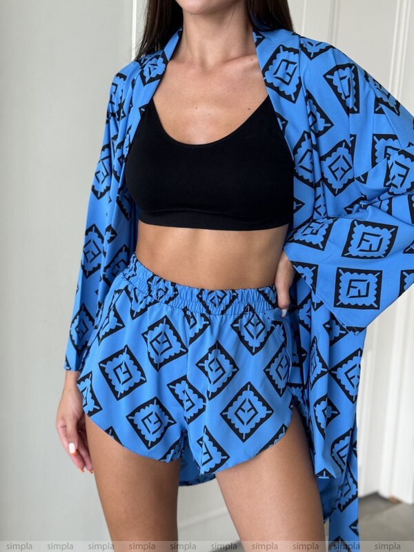 Person wearing a blue patterned kimono over a black sports bra and shorts.