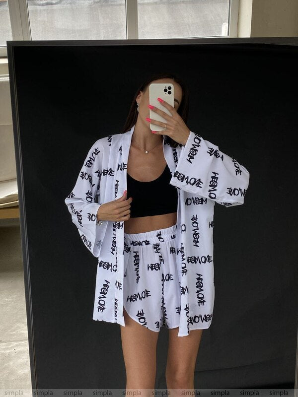 Person wearing a white kimono-style garment with black text in front of a mirror.