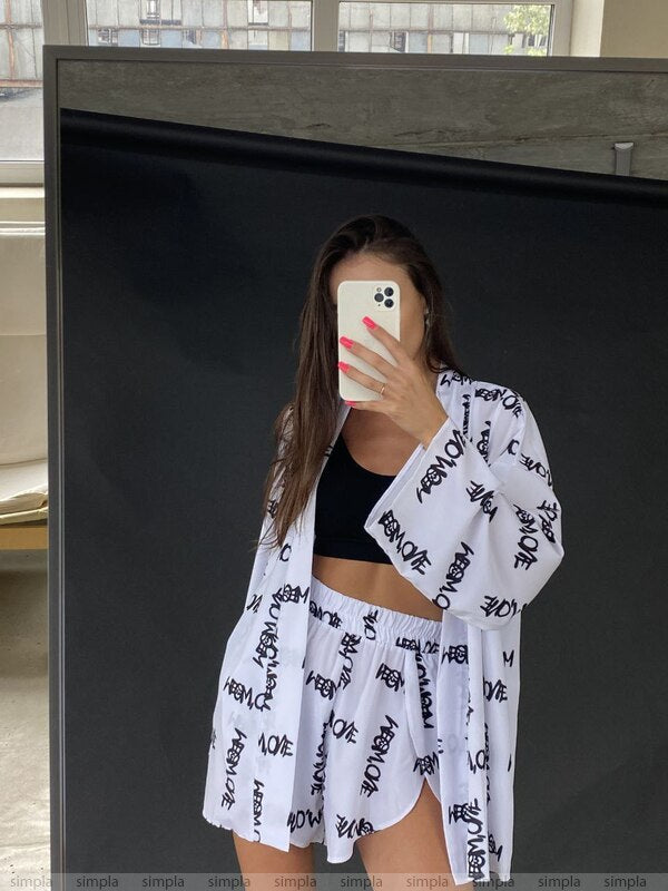 Person wearing a white kimono with black text in front of a mirror.
