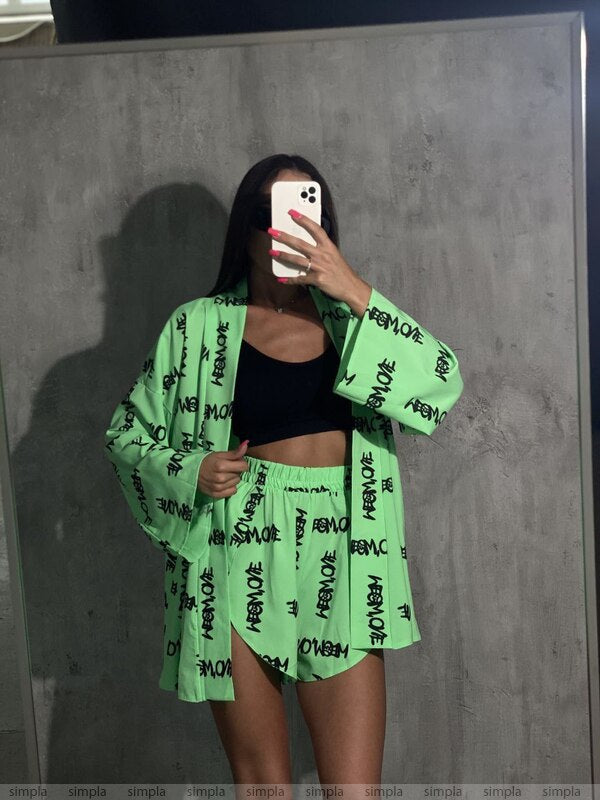 Person wearing a green outfit with text, taking a mirror selfie.
