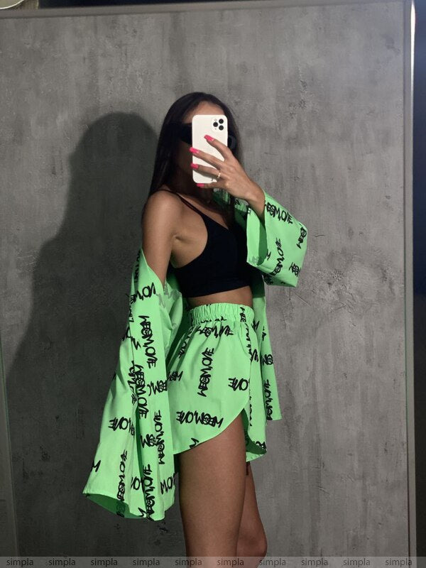 Person wearing a green kimono with black text against a gray wall.