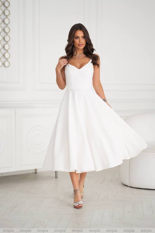 Woman wearing a white dress in a minimalistic room