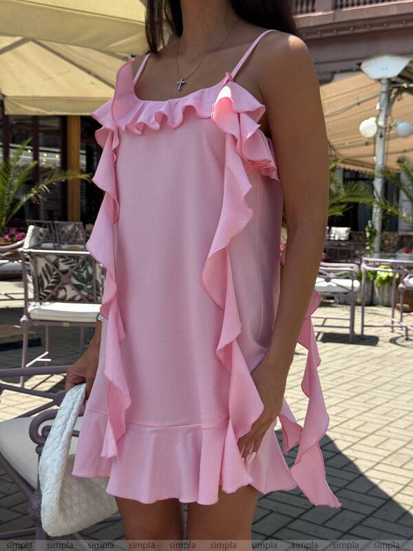 Person wearing a pink ruffled dress in an outdoor setting