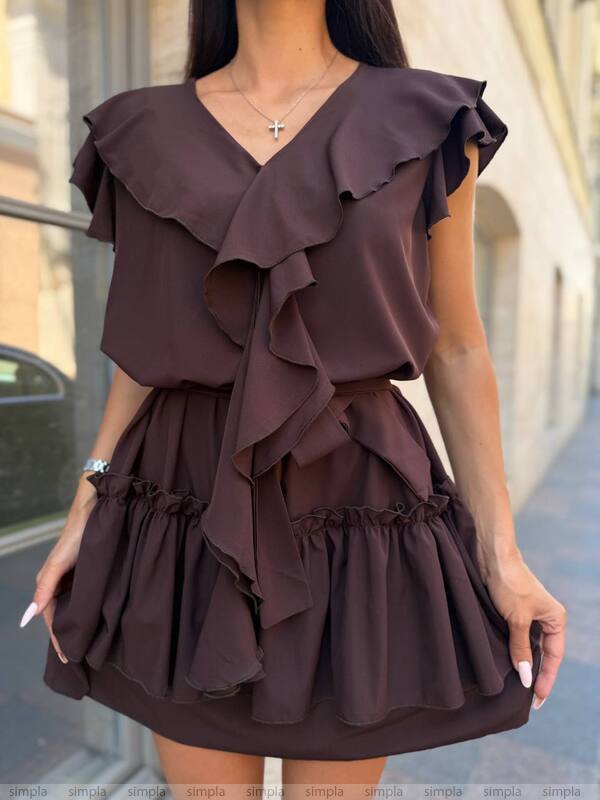 Woman wearing a brown ruffled dress on a blurred street background