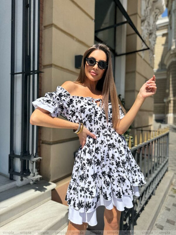 Woman wearing a black and white floral dress in an urban setting