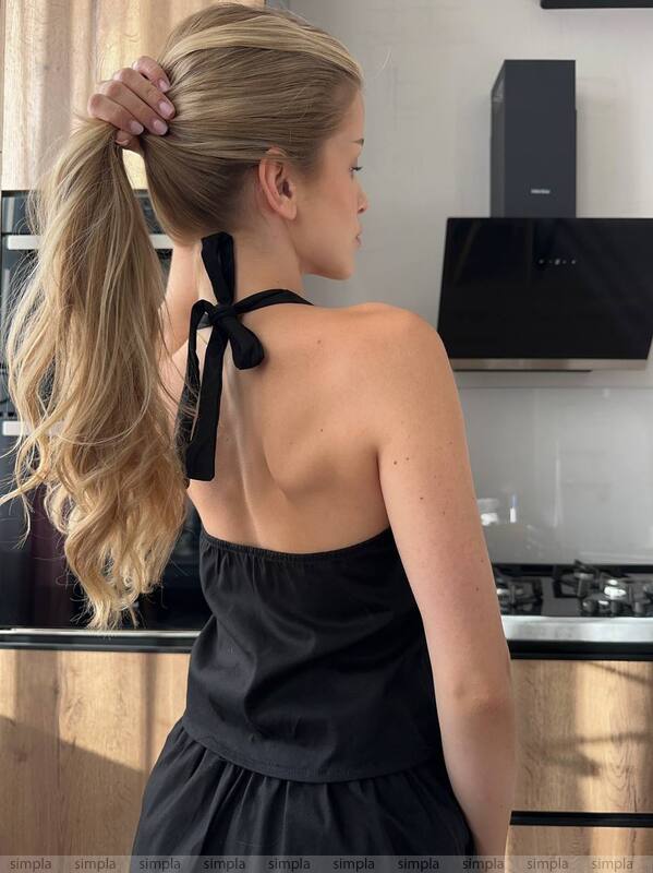 Woman in a black dress with a ponytail in a kitchen
