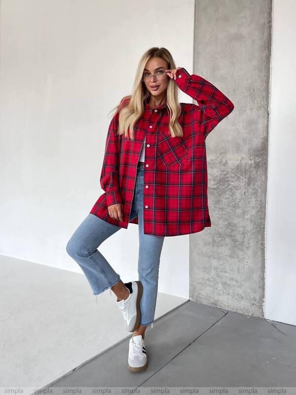 Person wearing a red plaid shirt and light blue jeans against a neutral background