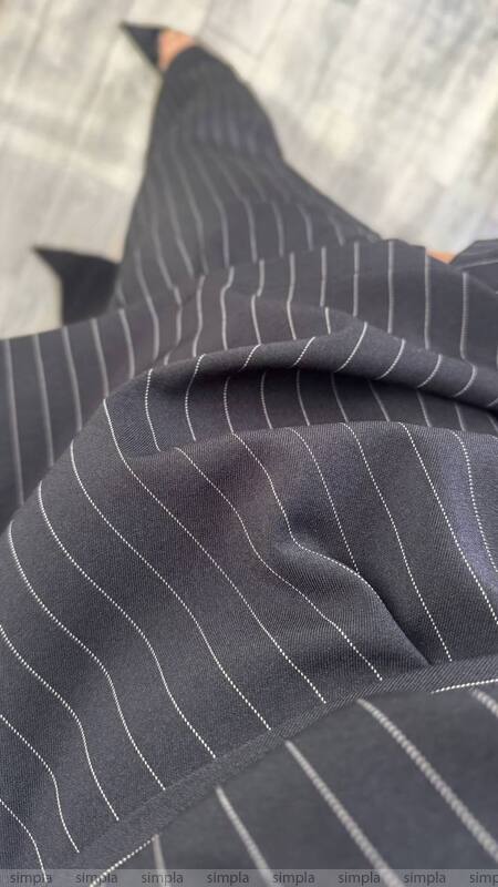 Close-up of a dark pinstripe suit with blurred background