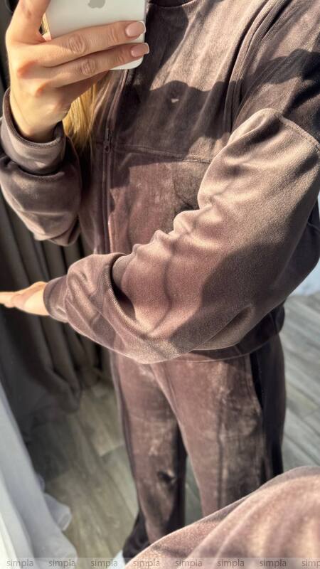 Person wearing a brown velour tracksuit taking a mirror selfie.