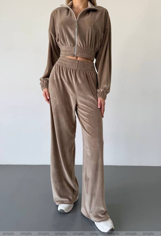 Brown tracksuit worn by a person on a plain background