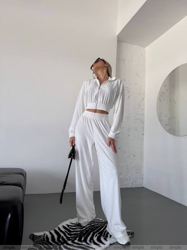 Person wearing a white outfit in a minimalistic room with a zebra-patterned rug.