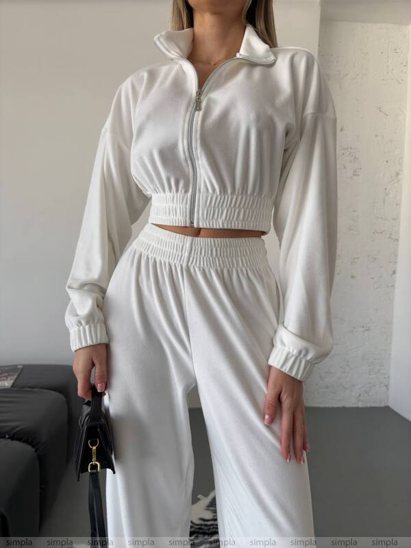 Person wearing a white tracksuit in an indoor setting
