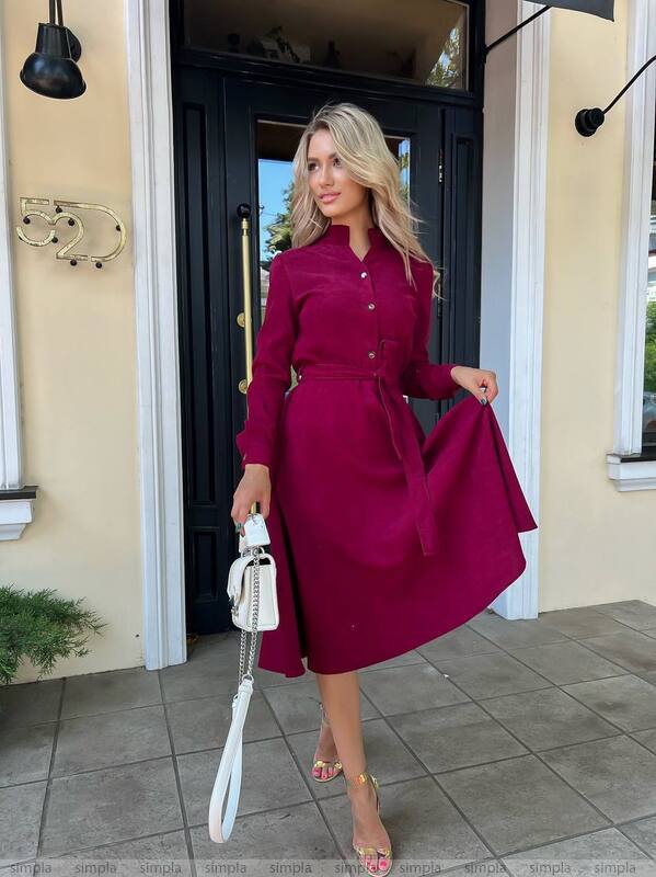 Woman in a magenta dress standing outside a building