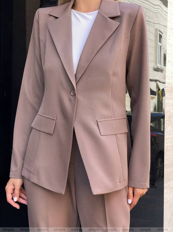 Person wearing a brown suit with a blurred background