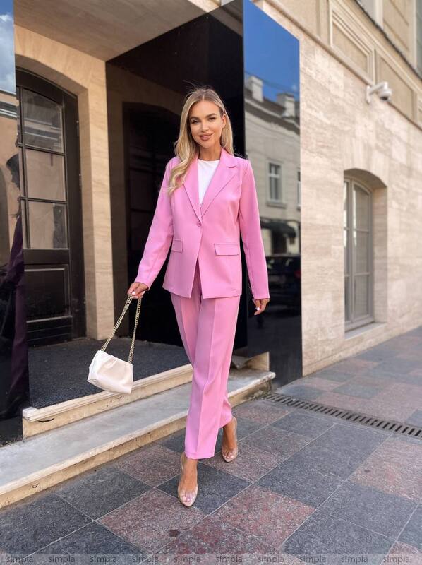 Woman in a pink suit standing outside a building