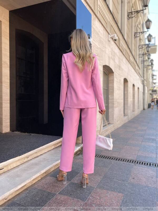 Woman in a pink suit walking down a street