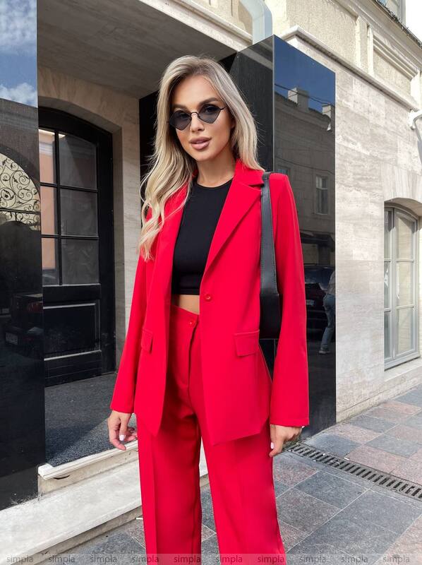Woman in a red suit standing in front of a building