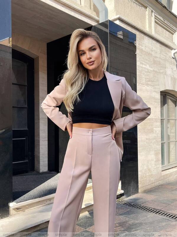 Woman in a stylish outfit standing in front of a building