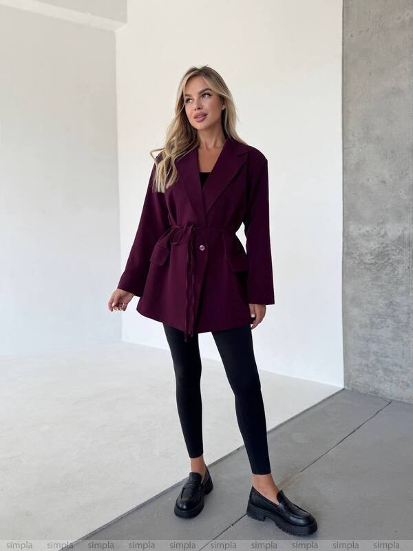 Woman wearing a burgundy coat in an indoor setting