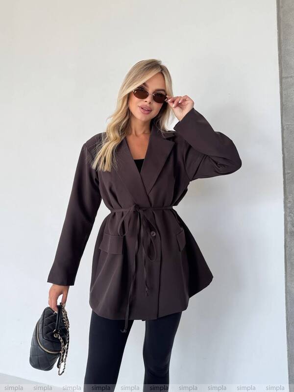 Woman wearing a brown coat with a plain background