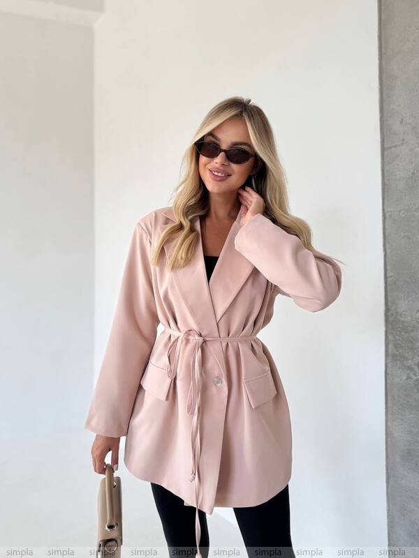 Woman wearing a pink coat with a plain background