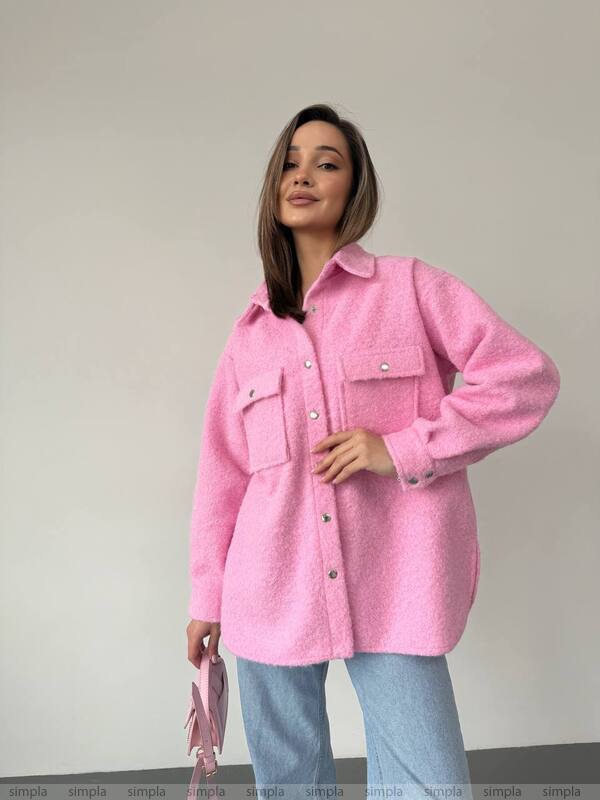 Woman wearing a pink coat against a plain background