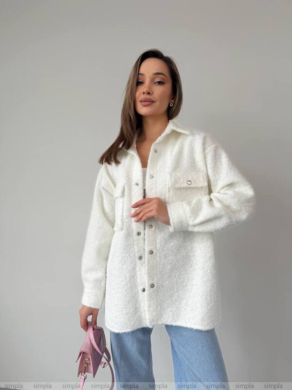 Woman wearing a white textured shirt against a plain background