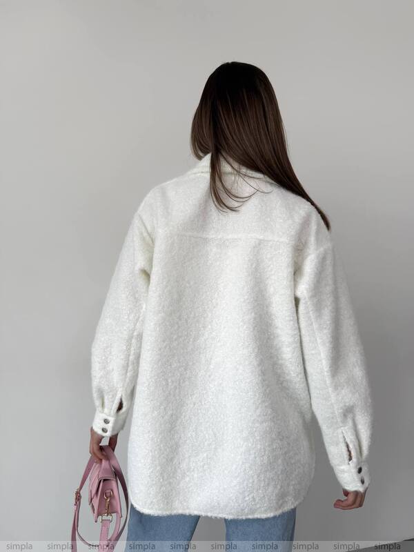 Person wearing a white textured jacket with a plain background