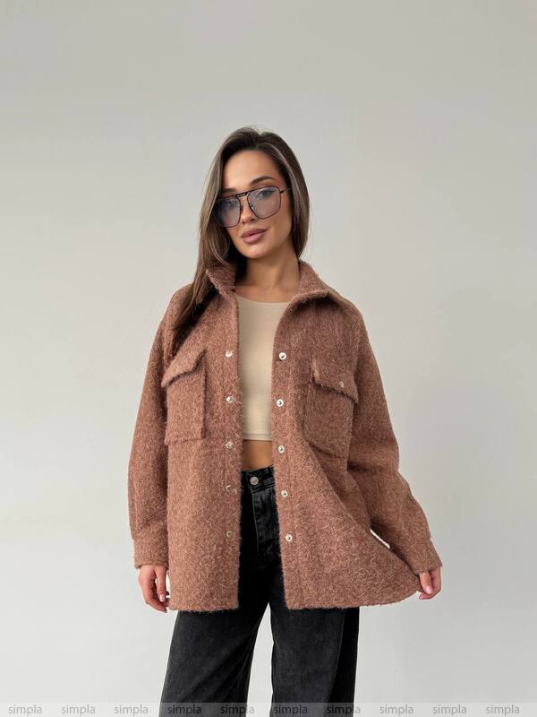 Woman wearing a brown coat against a plain background