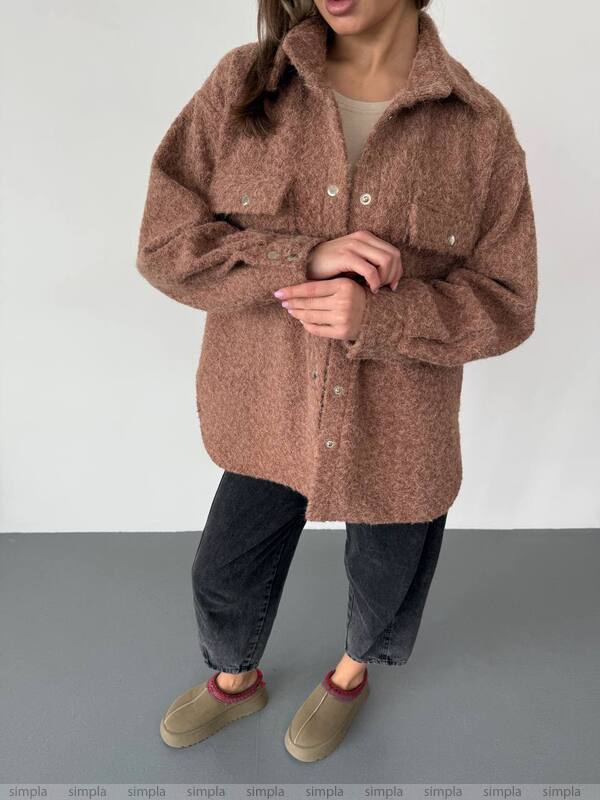 Person wearing a brown coat on a plain background