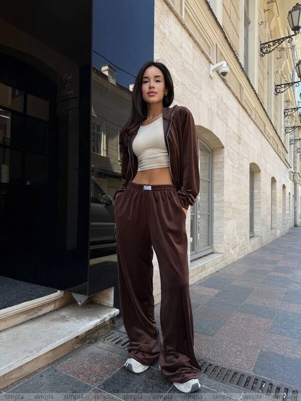 Woman in brown tracksuit standing on a city street
