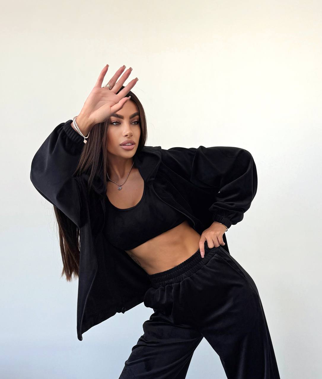 Person wearing a black outfit against a light background