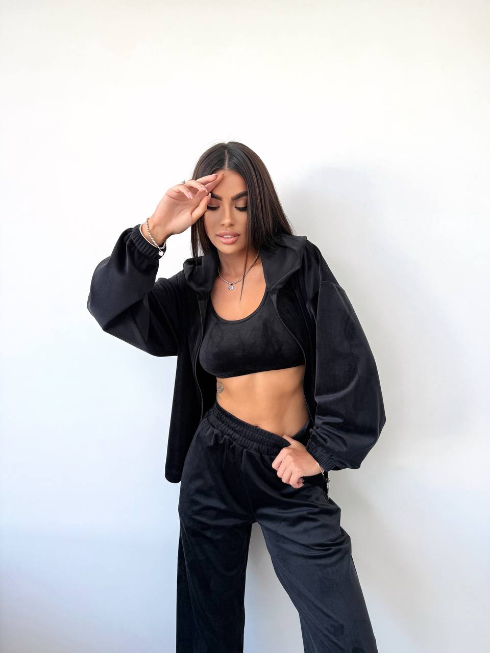 Woman wearing a black outfit against a white background
