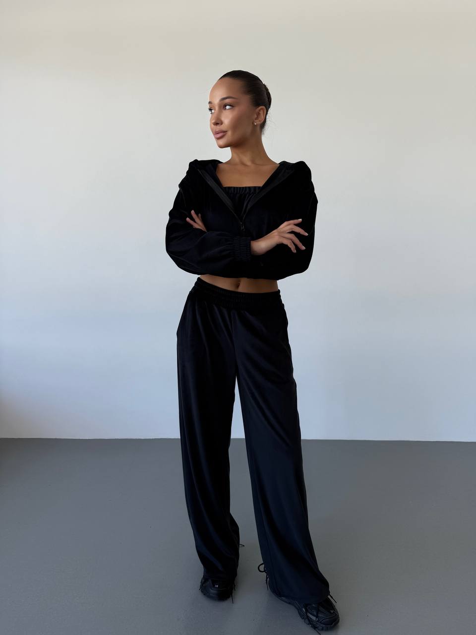Person wearing a black outfit against a plain background