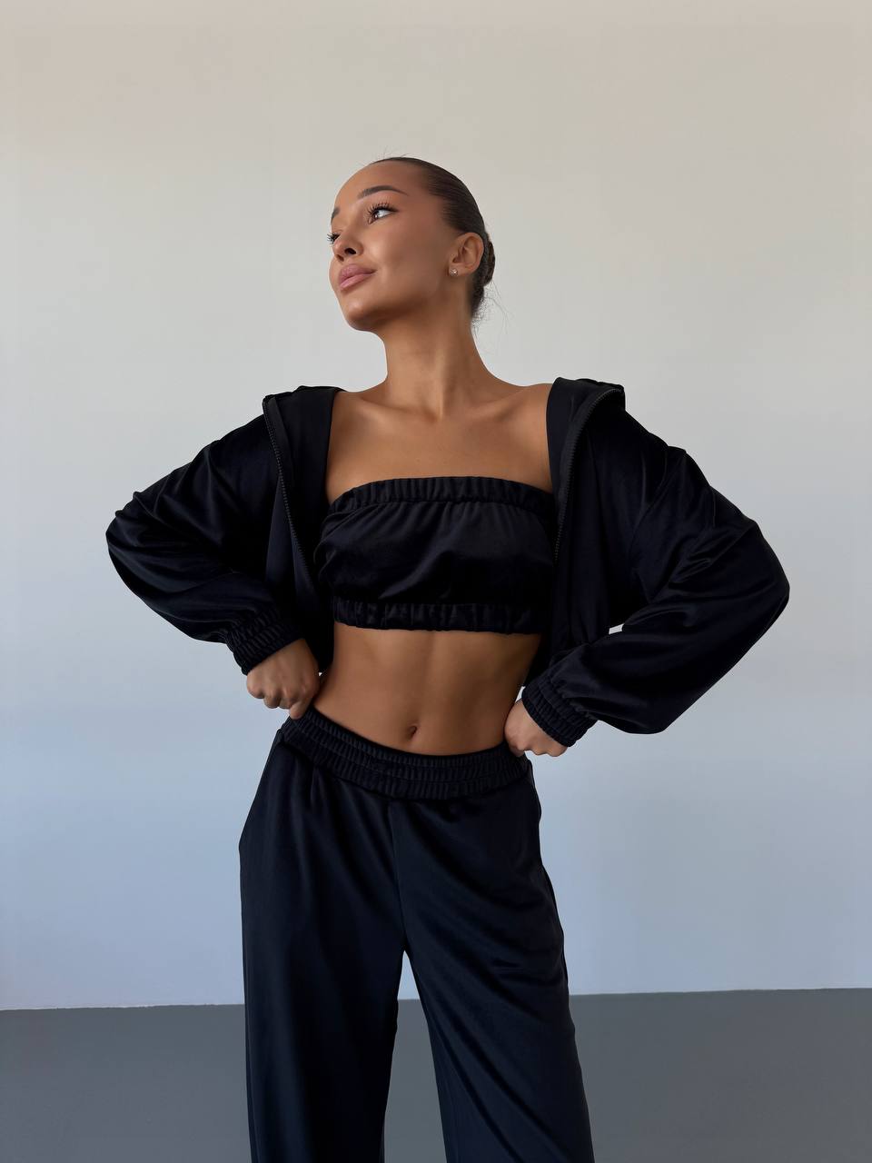 Person wearing a black outfit against a plain background