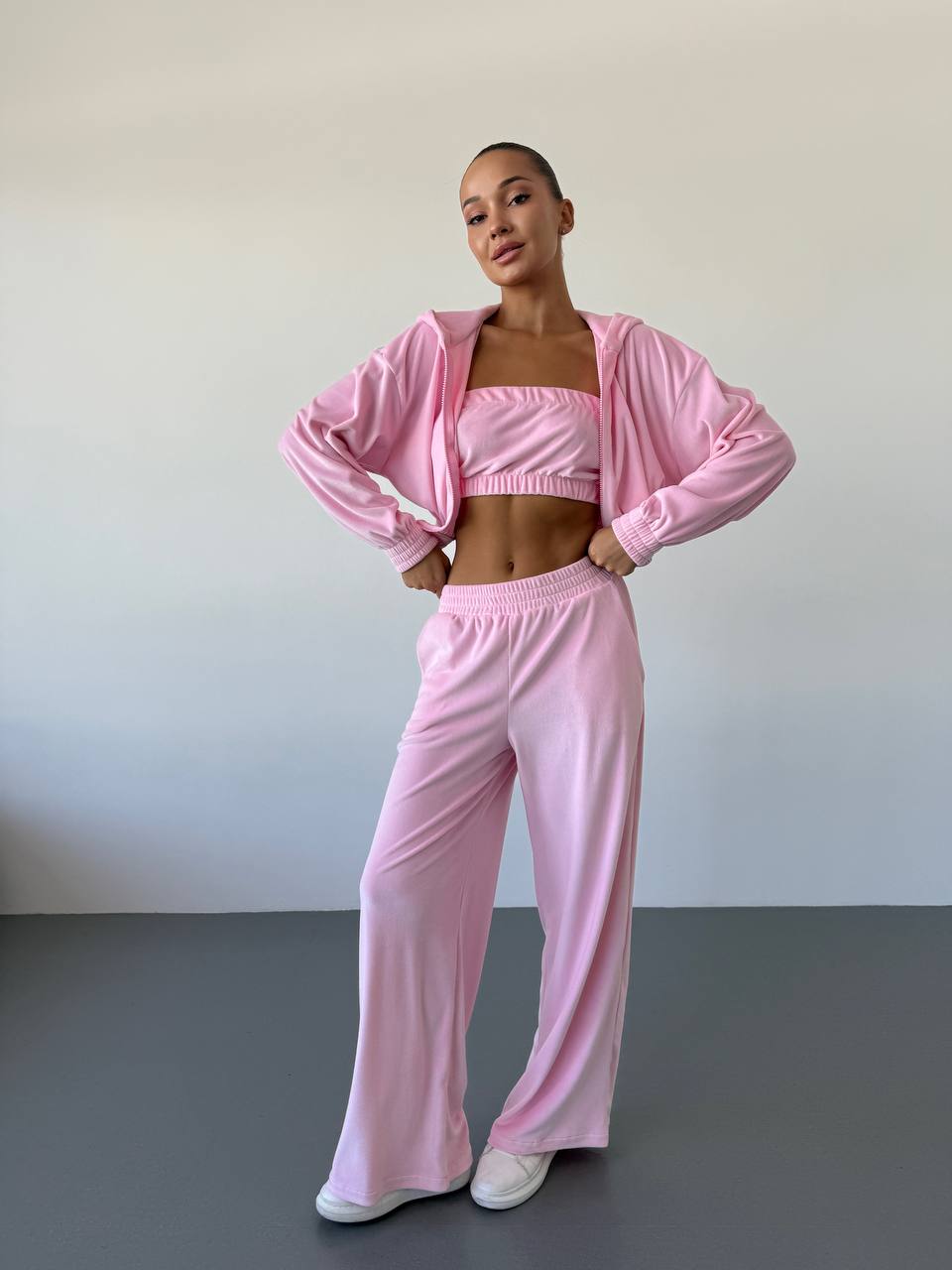 Person wearing a pink tracksuit against a plain background