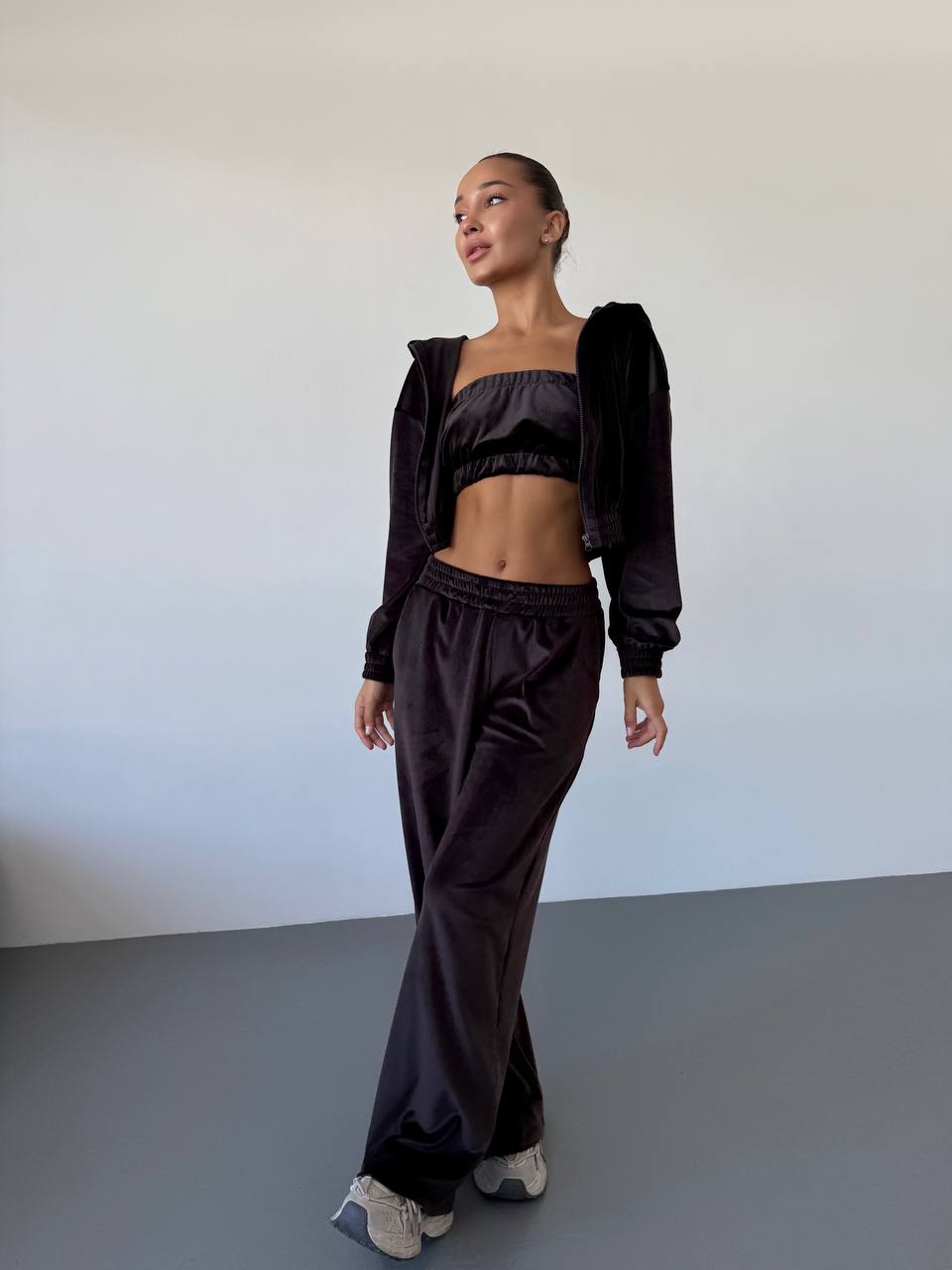 Woman wearing a black outfit against a plain background