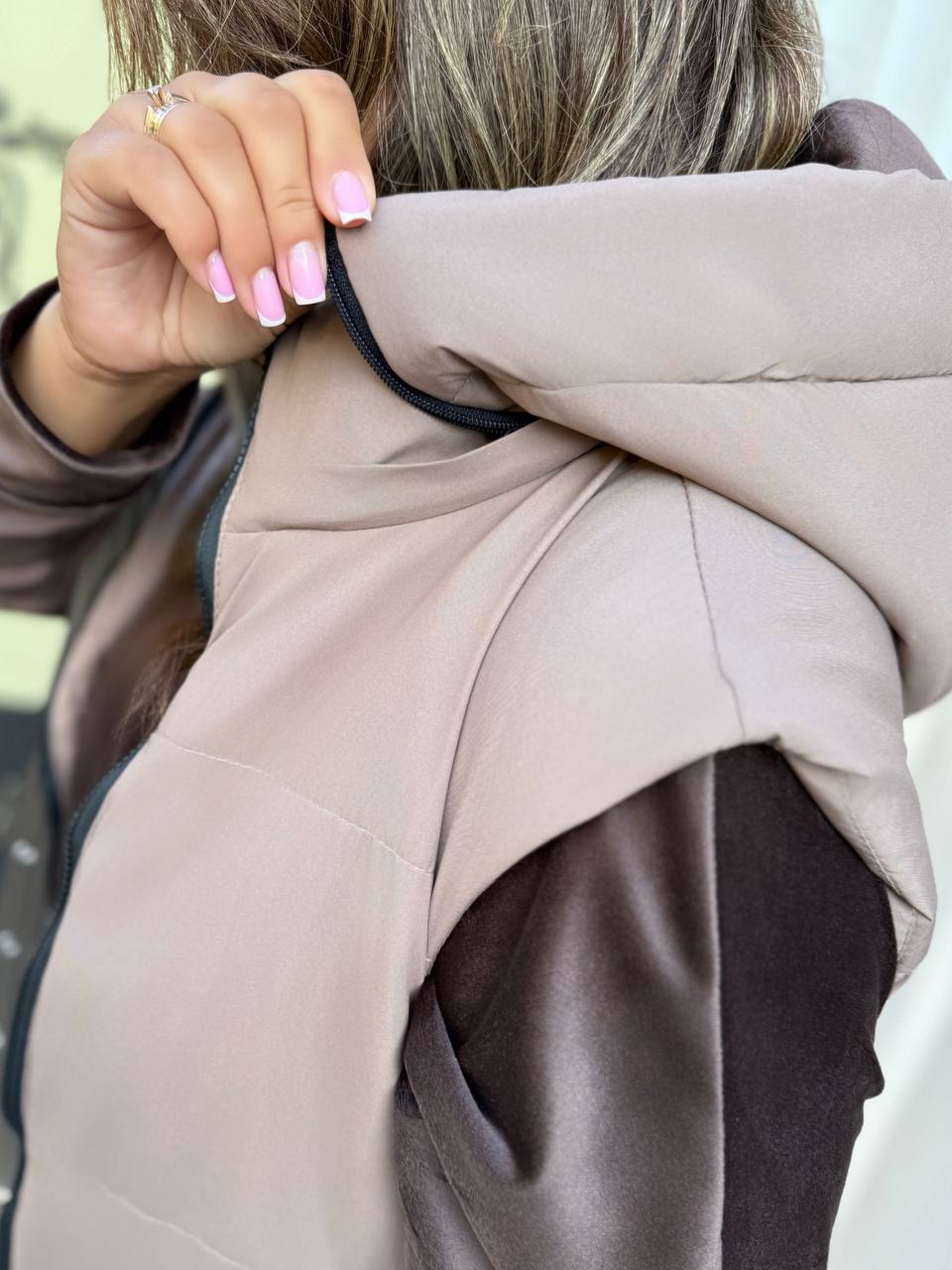 Close-up of a person wearing a beige coat with a blurred background