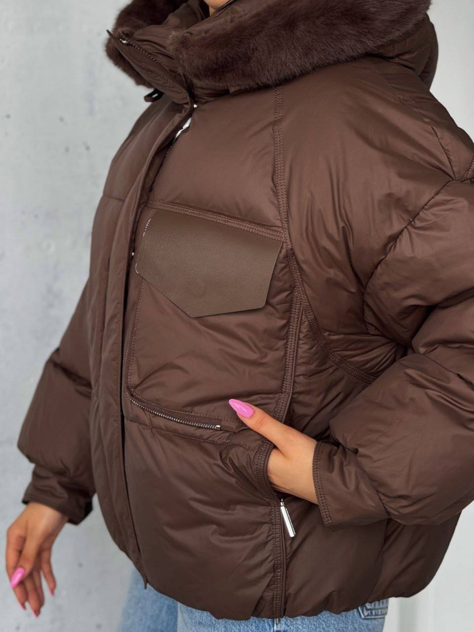 Brown puffer jacket with fur hood on a plain background
