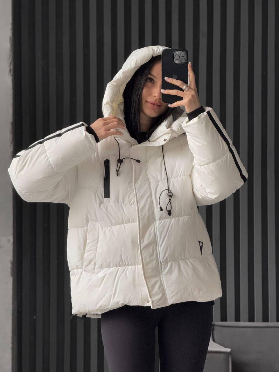 Person wearing a white puffer jacket with black accents, taking a mirror selfie.