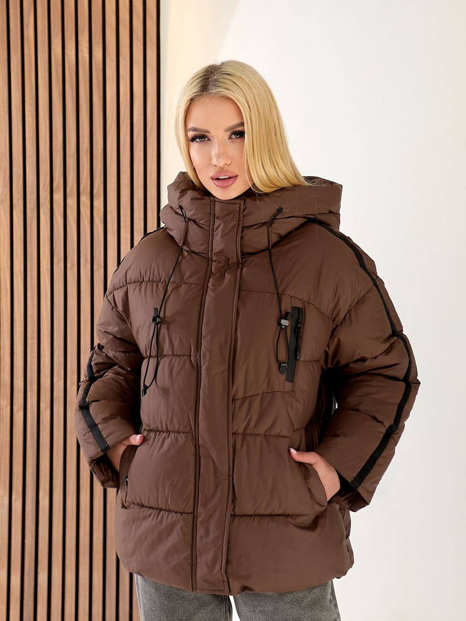 Woman wearing a brown winter coat with a neutral background