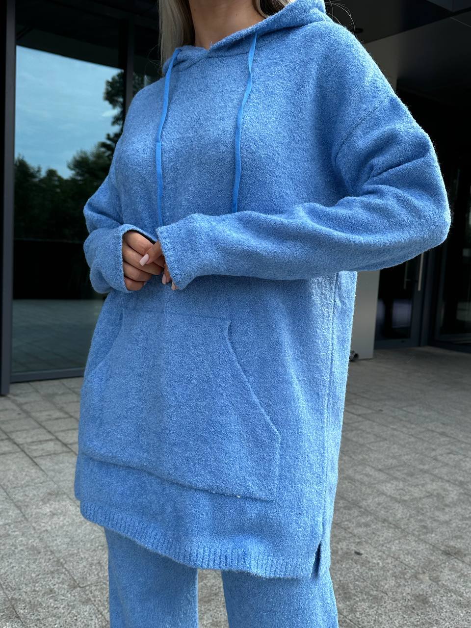 Person wearing a blue hoodie and pants in an outdoor setting