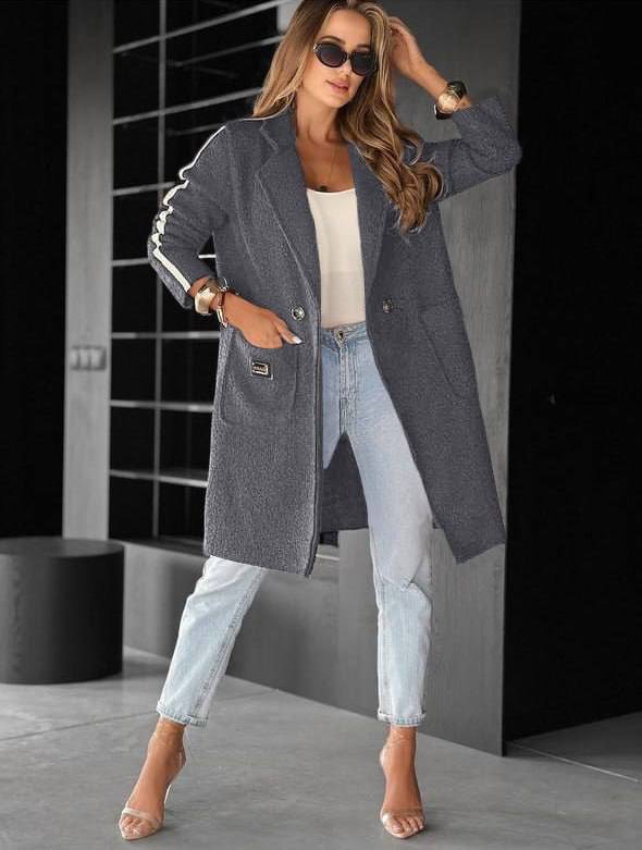 Woman wearing a long gray coat in an indoor setting