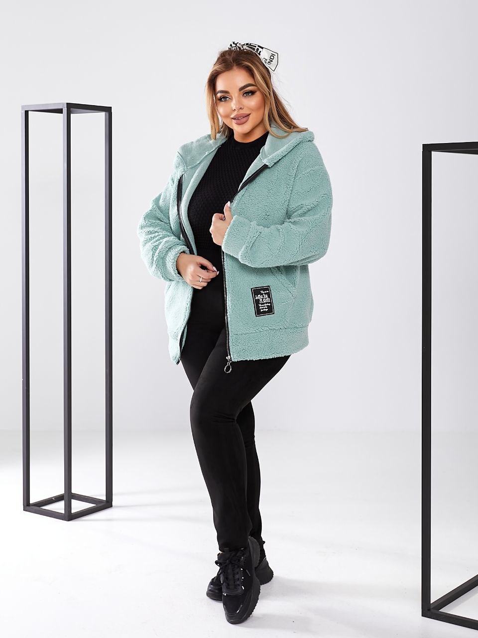 Woman wearing a light blue fleece jacket on a white background